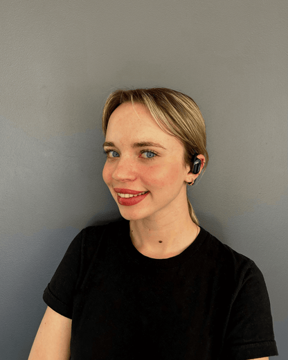 Femme souriante portant les écouteurs traducteurs Hearific, démonstration du port confortable et design élégant
